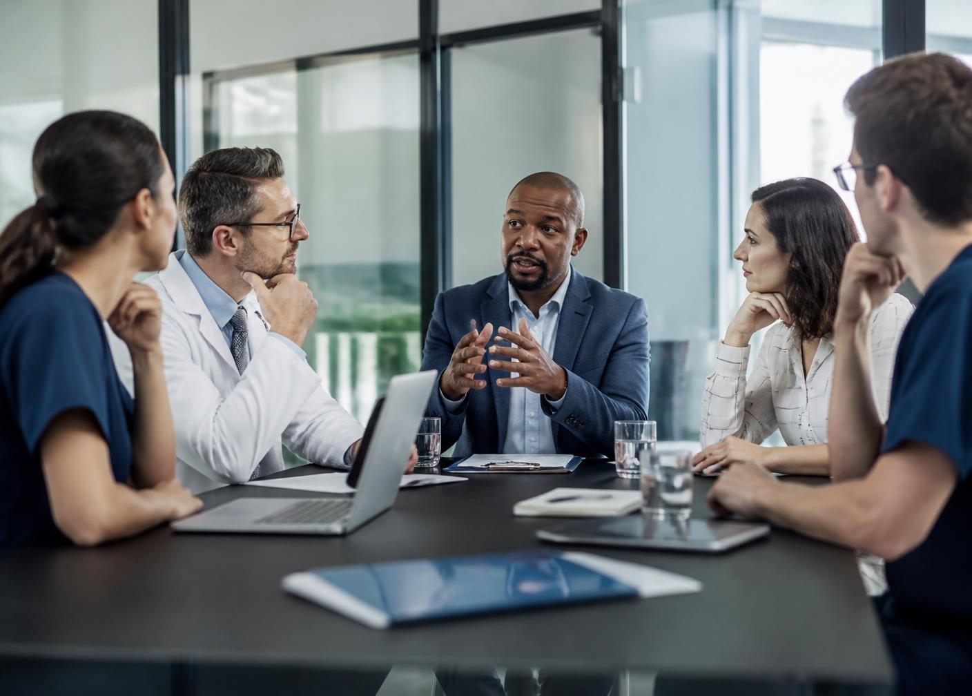 Clinicians and academic researchers in discussion around a conference table